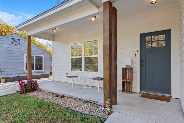 view of exterior entry featuring covered porch