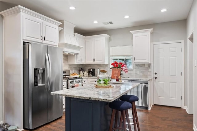 kitchen with white cabinets, custom exhaust hood, stainless steel appliances, and dark wood-type flooring