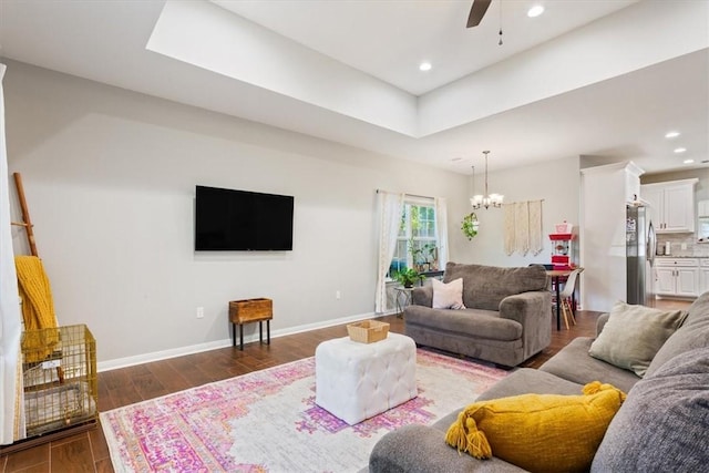 living room featuring ceiling fan with notable chandelier and dark hardwood / wood-style floors