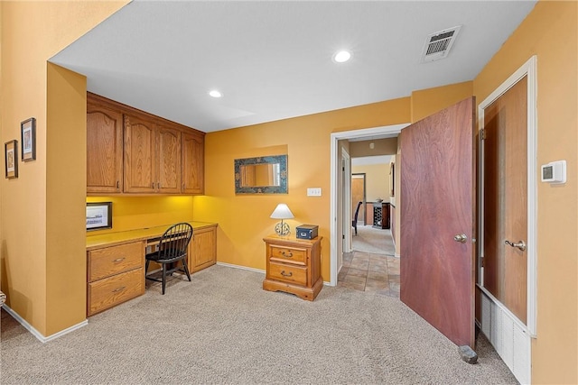 carpeted home office featuring built in desk