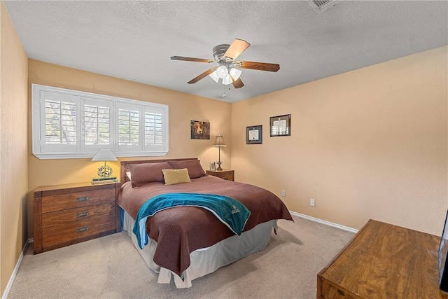 bedroom featuring light carpet, a textured ceiling, and ceiling fan