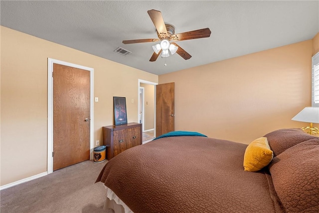 carpeted bedroom with ceiling fan and a textured ceiling