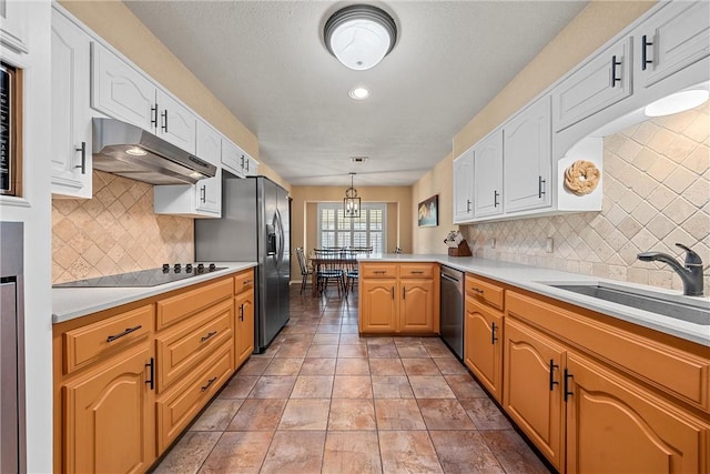 kitchen with pendant lighting, backsplash, appliances with stainless steel finishes, and sink