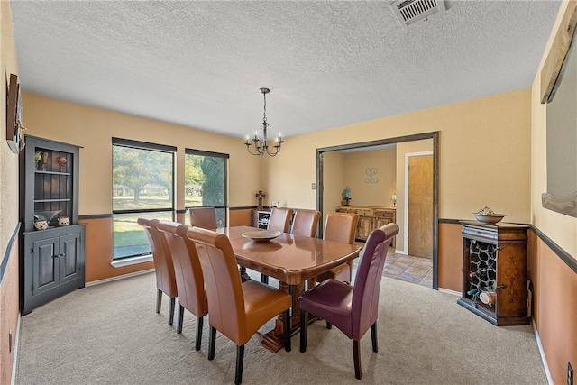 carpeted dining area featuring a chandelier and a textured ceiling