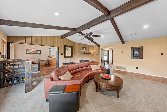 tiled living room featuring lofted ceiling with beams, ceiling fan, and wooden walls