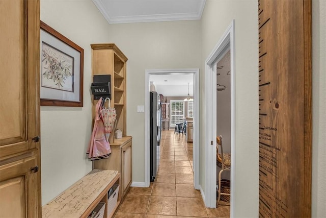 mudroom with light tile patterned flooring and crown molding