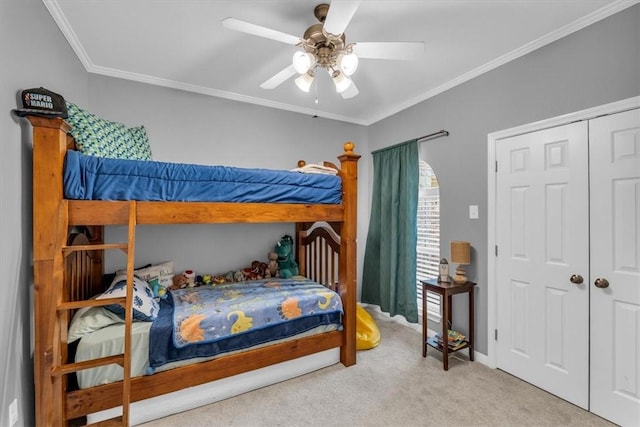 bedroom with ceiling fan, light colored carpet, crown molding, and a closet