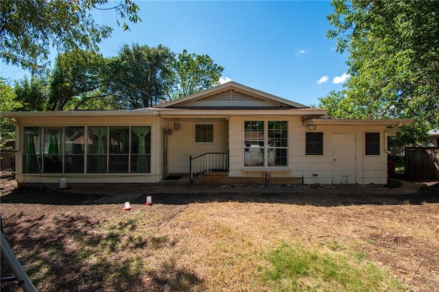 rear view of property featuring a sunroom