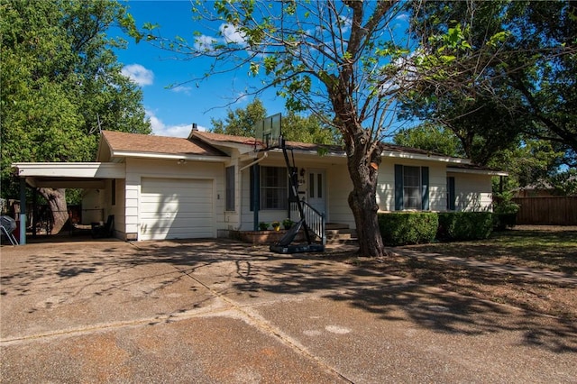 ranch-style house featuring driveway, a garage, and a carport