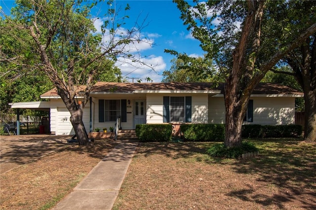 single story home featuring a carport, a front yard, driveway, and a garage