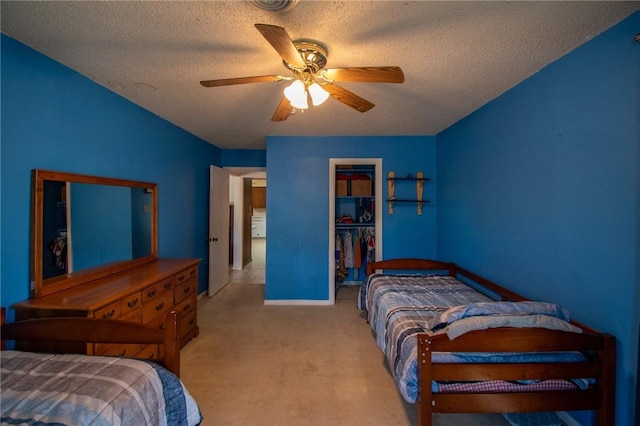 bedroom with ceiling fan, a closet, a textured ceiling, and light colored carpet