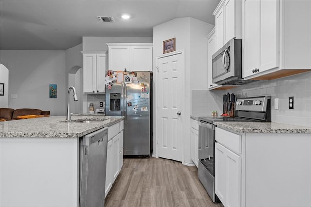 kitchen with visible vents, appliances with stainless steel finishes, light wood-style floors, white cabinetry, and a sink