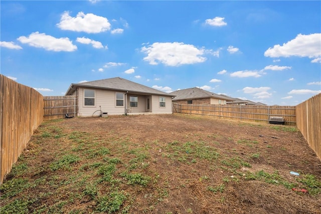 rear view of house with a fenced backyard