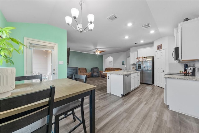 kitchen featuring a center island with sink, visible vents, appliances with stainless steel finishes, open floor plan, and a sink