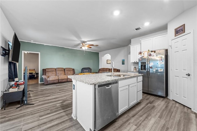 kitchen with stainless steel appliances, light wood finished floors, a sink, and visible vents