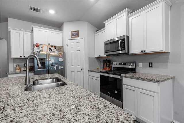 kitchen featuring tasteful backsplash, visible vents, white cabinets, appliances with stainless steel finishes, and a sink