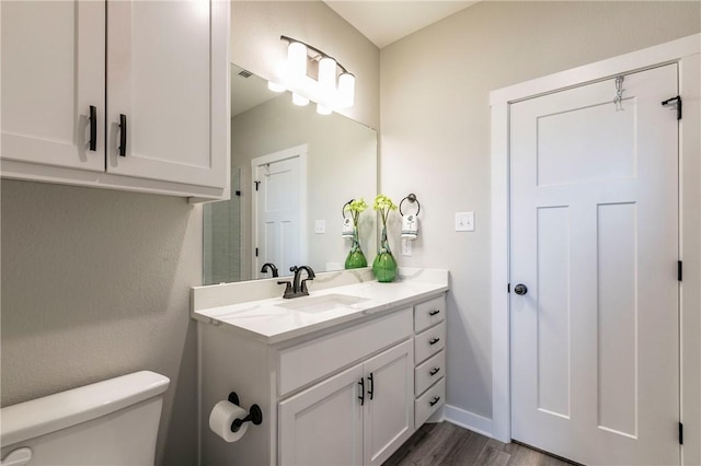 bathroom featuring hardwood / wood-style flooring, vanity, and toilet