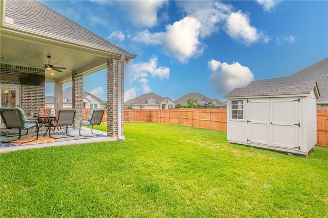 view of yard featuring a patio area, ceiling fan, and a storage shed