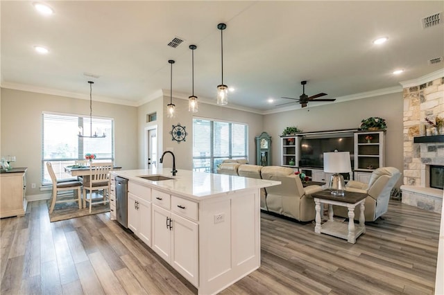 kitchen with a center island with sink, a healthy amount of sunlight, white cabinets, and sink