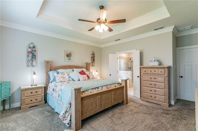 bedroom with ceiling fan, a raised ceiling, light colored carpet, and ensuite bath