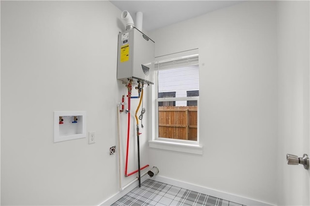 clothes washing area featuring tankless water heater and washer hookup