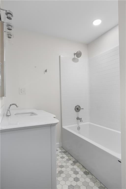 bathroom with tiled shower / bath combo and vanity