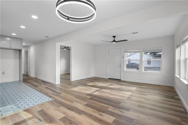 unfurnished living room with ceiling fan, a wealth of natural light, and hardwood / wood-style floors