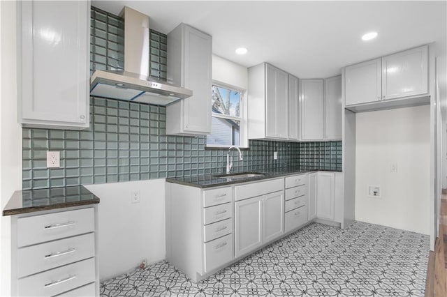 kitchen featuring sink, white cabinets, decorative backsplash, and wall chimney exhaust hood