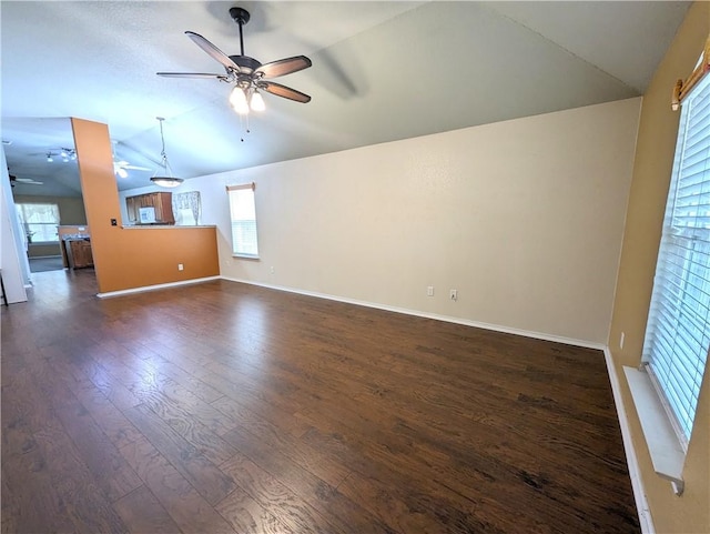 spare room featuring ceiling fan, dark wood-type flooring, and vaulted ceiling