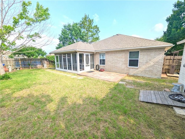 back of house with a sunroom, a patio area, and a yard