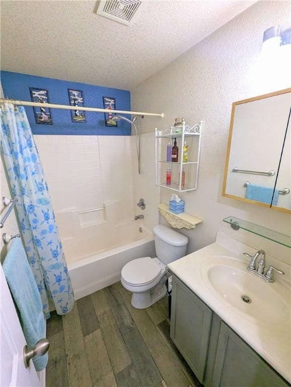 full bathroom featuring a textured ceiling, vanity, shower / tub combo with curtain, wood-type flooring, and toilet