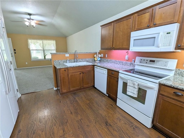 kitchen featuring lofted ceiling, white appliances, dark wood-type flooring, sink, and light stone countertops