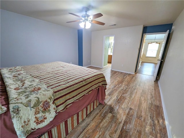 bedroom with ceiling fan, ensuite bathroom, and hardwood / wood-style flooring