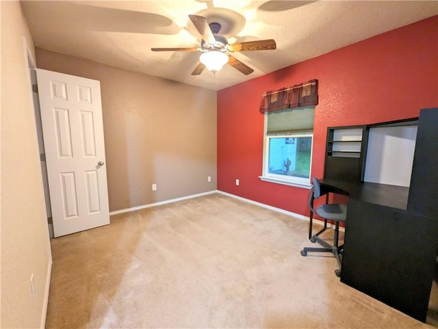 unfurnished office featuring ceiling fan, light colored carpet, and a textured ceiling