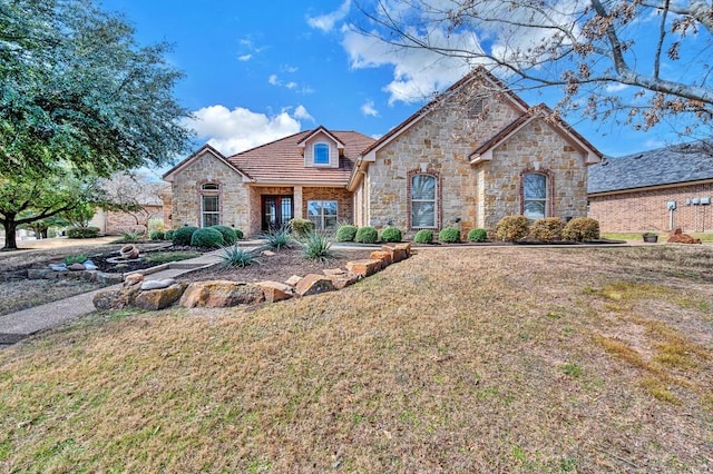 french country inspired facade with a front yard