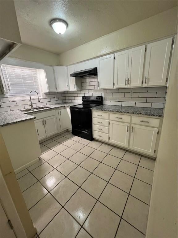 kitchen with black range with electric stovetop, light stone countertops, sink, and white cabinets