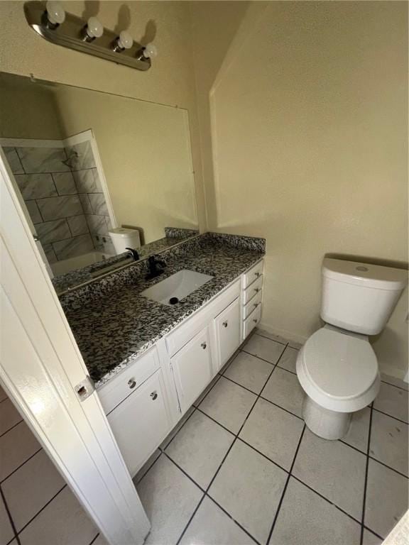 bathroom featuring vanity, tile patterned floors, and toilet