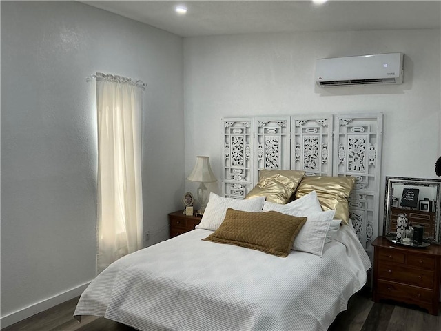 bedroom with a wall mounted air conditioner and dark hardwood / wood-style flooring