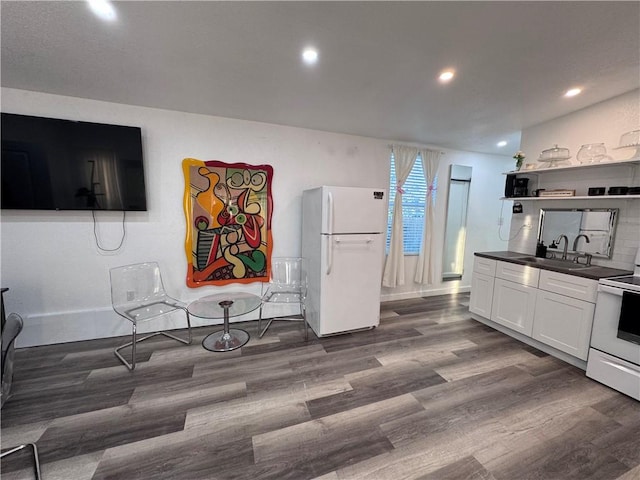 kitchen featuring sink, white cabinets, dark wood-type flooring, and white appliances