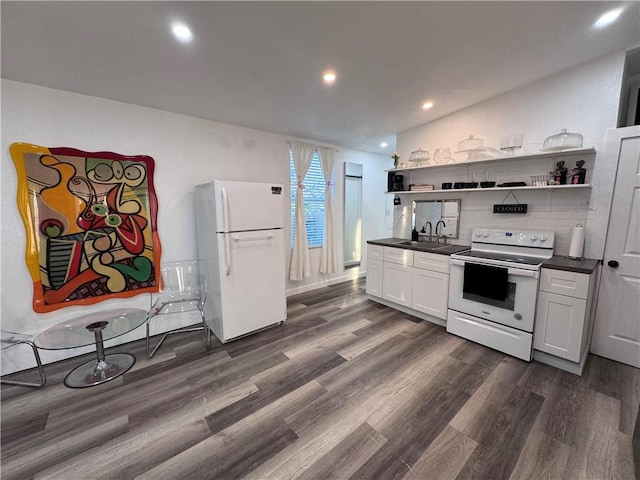 kitchen featuring dark hardwood / wood-style flooring, white appliances, sink, white cabinetry, and lofted ceiling