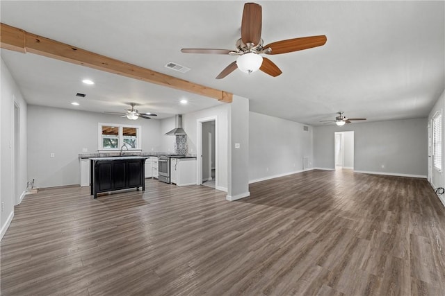 unfurnished living room with a wealth of natural light, dark hardwood / wood-style floors, sink, and ceiling fan