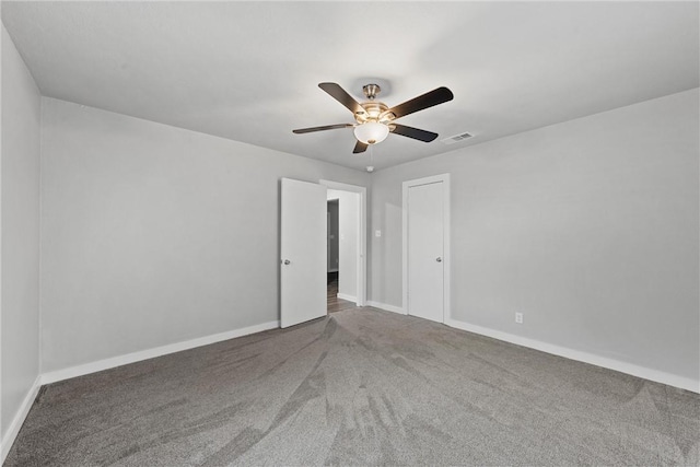 carpeted spare room featuring ceiling fan