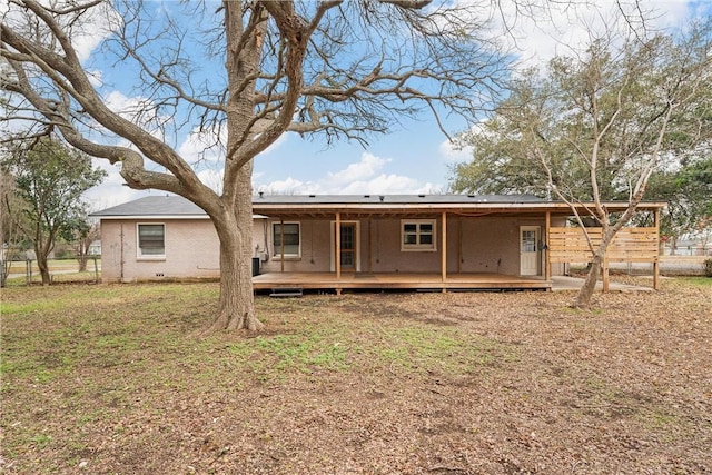 rear view of house featuring a lawn and a deck