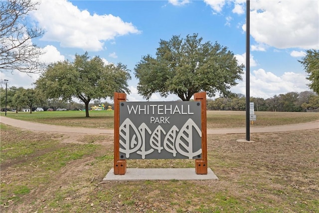 community / neighborhood sign featuring a lawn