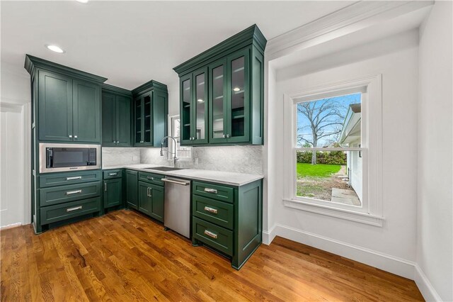 kitchen featuring sink, stainless steel appliances, dark hardwood / wood-style flooring, decorative backsplash, and green cabinetry