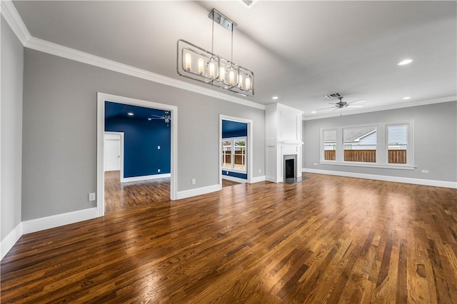 unfurnished living room featuring crown molding, ceiling fan with notable chandelier, and dark hardwood / wood-style floors