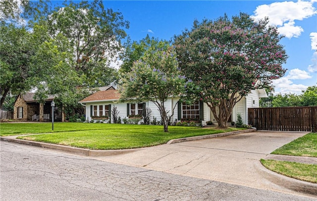 view of property hidden behind natural elements featuring a front yard