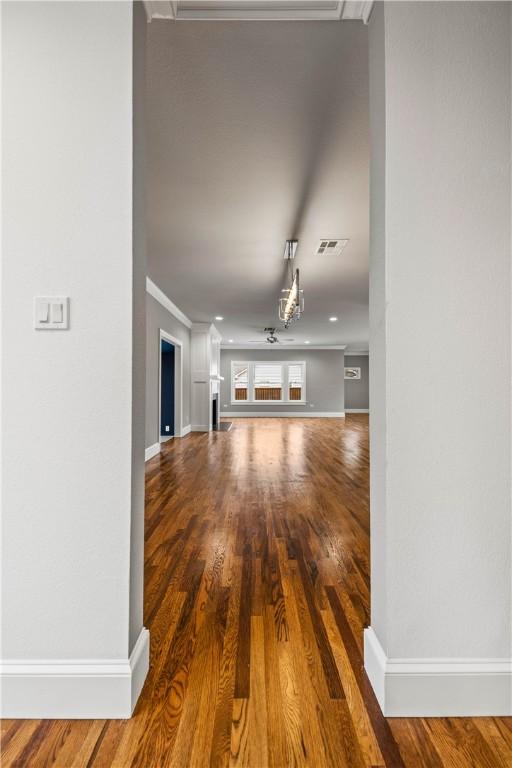 unfurnished living room with hardwood / wood-style flooring and ornamental molding