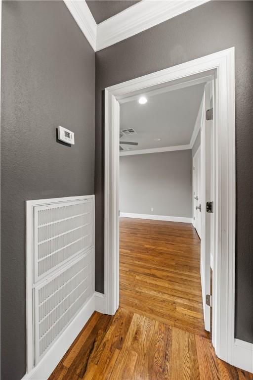 corridor featuring light hardwood / wood-style flooring and crown molding