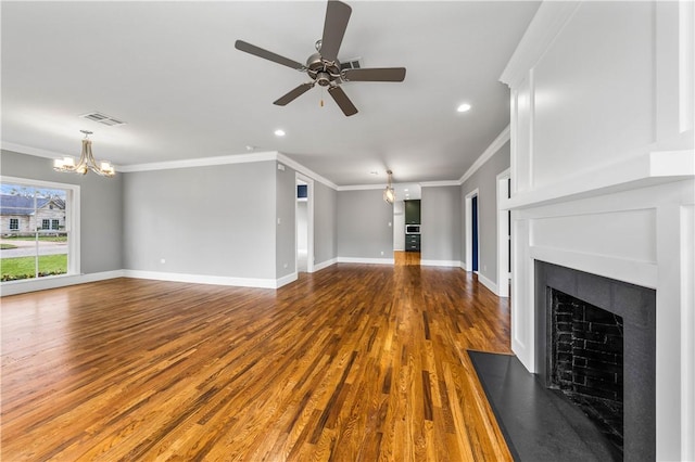 unfurnished living room featuring crown molding, ceiling fan with notable chandelier, and hardwood / wood-style flooring